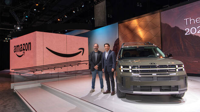 Marty Mallick (left), Amazon’s vice president for worldwide business and corporate development, and Jose Munoz, global chief operating officer at Hyundai Motor Group, pose for a photo next to the all-new Santa Fe at the LA Auto Show in the Los Angeles Convention Center in California, the US, on Nov. 16. (Hyundai Motor Group)