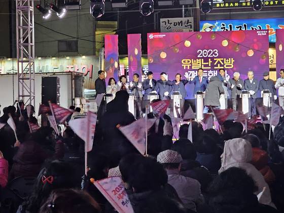 A lighting ceremony for winter season street decorations is held in Dong District, Busan, with its mayor Kim Jin-hong on stage, ahead of the final decision for the hosting city of the 2030 World Expo to be decided. Dong District residents who attended the event wave flags supporting Busan's bid. [SHIN HA-NEE]