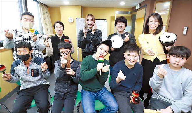발달장애인 김세헌 씨(왼쪽 아래부터), 한정민 씨, 이한얼 씨, 김승빈 씨, 장은준 씨가 지난 27일 ‘취약계층 음악정서지원 프로그램’에 참여한 교수, 치료사 등과 함께 악기를 흔들고 있다. LG유플러스 제공
