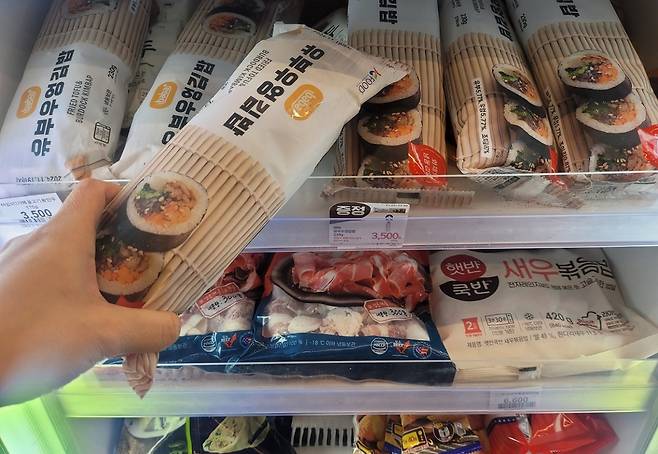 30일 서울 성수동 이마트24 매장에서 한 소비자가 유부우엉 김밥을 구입하고 있다./ 이마트24