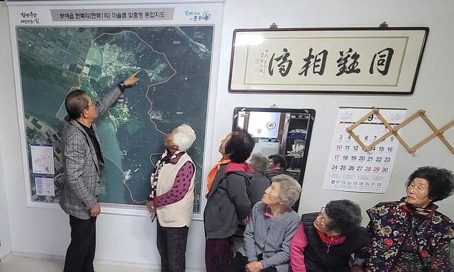 김윤창 부여군 부여읍 현북1리 이장(왼쪽)이 마을회관에서 주민들과 마을별 맞춤형 종합지도를 살펴보고 있다. 부여군 제공