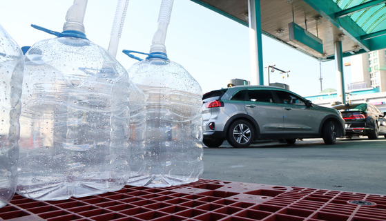 Empty bottles of diesel exhaustion fluid made of urea are placed at a gas station in Goyang, Gyeonggi on Monday. [YONHAP]