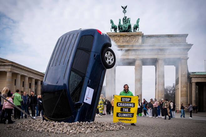 그린피스 활동가가 SUV 옆에서 지난 3월 22일 내연기관차 폐지를 촉구하는 퍼포먼스를 벌이고 있다. 그린피스 제공