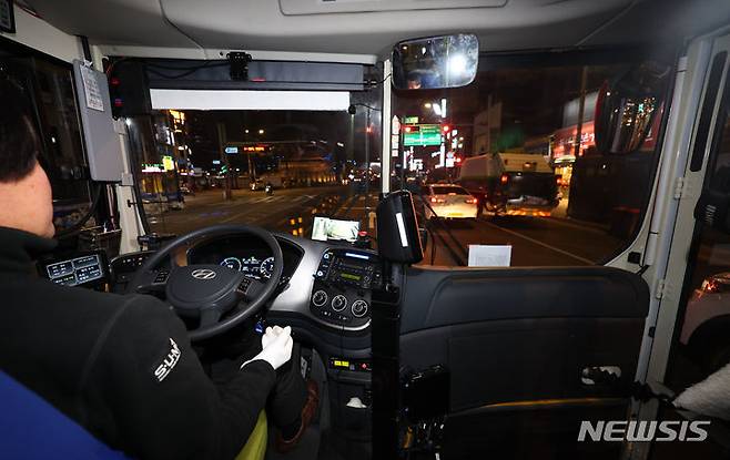 [서울=뉴시스] 최진석 기자 = 4일 서울 종로구 동대문역.흥인지문 버스정류장에서 출발한 '심야A21번' 심야자율버스 운전자가 운전대에서 손을 놓고 있다. 2023.12.05. myjs@newsis.com