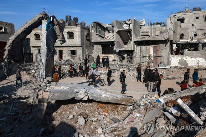 가자지구 남부 라파에서 이스라엘 공습 이후 주거용 건물의 피해 정도를 살펴보고 있는 팔레스타인인들 [AFP=연합뉴스]