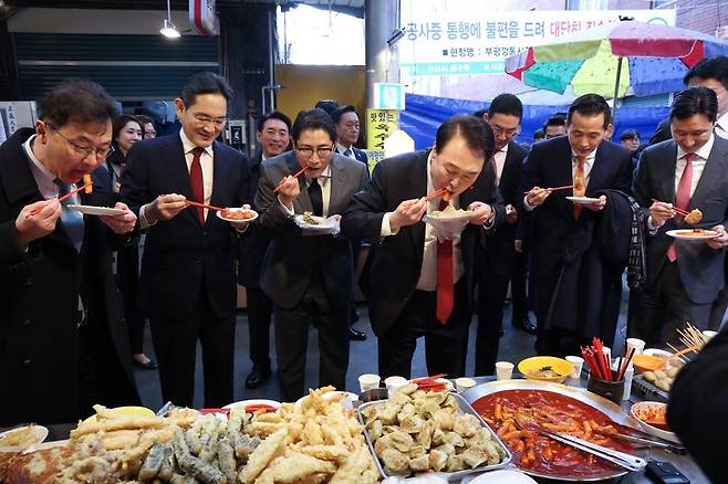 윤석열 대통령과 이재용 삼성전자 회장, 구광모 엘지(LG)그룹 회장, 정기선 에이치디(HD)현대 부회장, 김동관 한화그룹 부회장, 조현준 효성그룹 회장, 최재원 에스케이(SK)수석부회장 등 대기업 총수들이 6일 부산 중구 깡통시장을 방문해 떡볶이와 빈대떡을 시식하고 있다. 대통령실사진기자단 
