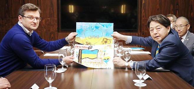 2일(현지 시각) 폴란드 수도 바르샤바를 방문한 하야시 요시마사(오른쪽) 일본 외무상이 드미트로 쿨레바 우크라이나 외교장관에게 일본 어린이가 우크라이나 평화를 기원하며 그린 그림을 전달하고 있다. /교도 연합뉴스