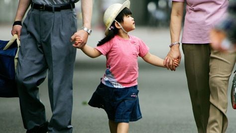 일본 도쿄 시내에서 한 여자 어린이가 할아버지·할머니의 손을 잡고 걸어가고 있다./조선일보DB