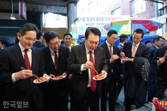 윤석열 대통령과 이재용 삼성전자 회장 등 참석자들이 6일 부산 중구 부평깡통시장에서 떡볶이, 만두 등 분식을 먹고 있다. 부산=서재훈 기자