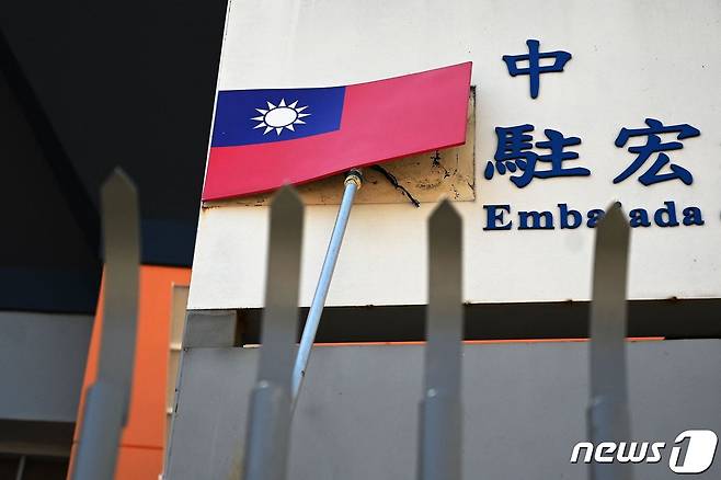 27일(현지시간) 자국과 단교하고 중국과 정식으로 수교한 온두라스의 테구시갈파에 있는 대만 대사관 건물 벽에서 직원이 국기를 떼어내고 있다. ⓒ AFP=뉴스1 ⓒ News1 우동명 기자
