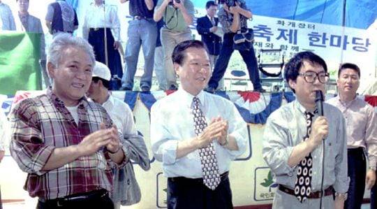 소설가 김한길(왼쪽)이 1996년 8월 경남 하동 화개장터에서 열린 '동서화합 축제 한마당'에서 김대중(가운데) 국민회의 총재, 가수 조영남(오른쪽)과 '화개장터'를 부르는 모습 /조선일보DB