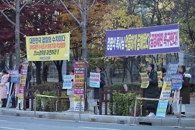 기독교복음선교회(JMS) 총재 정명석씨의 여신도 성폭행 혐의 재판이 다섯 달 만에 열리는 대전 서구 둔산동 대전지법 인근에서 JMS 신도들이 11월21일 피켓 시위를 하고 있다. ⓒ연합뉴스