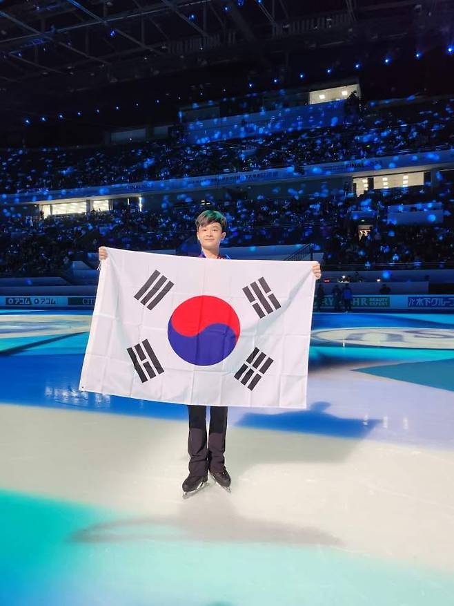 피겨 남자 싱글 차세대 주자로 꼽히는 김현겸(한광고)이 9일(한국시간) 중국 베이징에서 열린 2023-2024 ISU 피겨 주니어 그랑프리 파이널 남자 싱글 프리스케이팅에서 은메달을 차지한 뒤 태극기를 들고 포즈를 취하고 있다. [연합]
