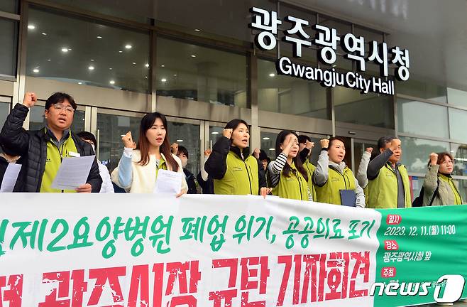 전국보건의료노조 광주전남지역본부가 11일 오전 광주시청 앞에서 기자회견을 열고 이달 말 전남대병원의 위수탁 계약기간 만료로 폐업 위기에 처한 광주시립제2요양병원 사태의 본질로 광주시의 '그릇된 보건의료 정책'을 주장하며 시를 규탄하고 있다. 2023.12.11/뉴스1 ⓒ News1 이승현 기자