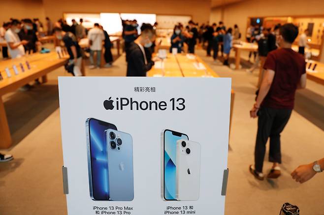 지난 24일 중국 베이징에 있는 애플 매장에서 시민들이 새로 출시된 애플의 스마트폰 아이폰 13을 보고 있다. 일본 닛케이 아시아는 27일 최근 중국의 전력 부족으로 장쑤성이 산업용 전력 공급을 제한하면서 일부 애플 협력업체 공장들이 이달 말까지 가동을 중단했다고 보도했다./로이터 연합뉴스