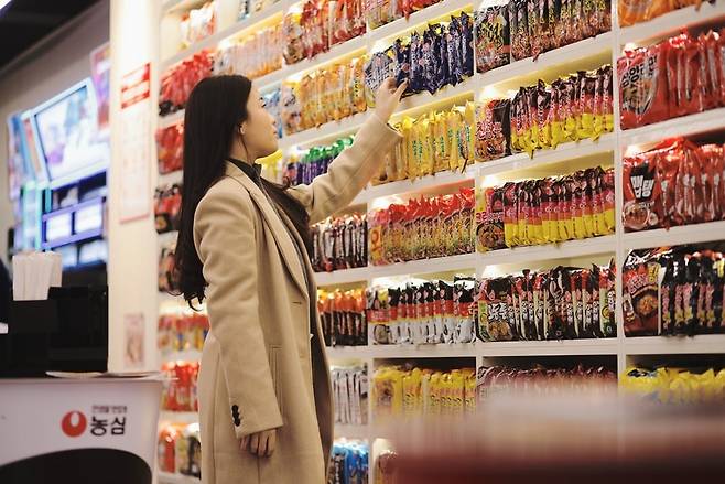 한 소비자가 서울 서교동 CU홍대상상점의 라면 진열대에서 라면을 고르고 있다./ BGF리테일 제공