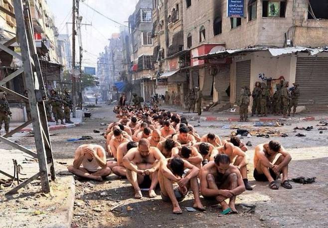 이스라엘군에 붙잡혀 속옷만 입은 채 거리에 줄지어 앉은 팔레스타인 남성들 ⓒ로이터=연합뉴스