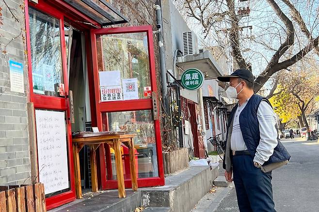지난 22일 식탁으로 문을 가로막은 베이징의 한 식당 앞에 시민이 서 있다. "잠깐만 들어가서 밥 먹을 수 있느냐"라고 물었지만, 상부 지침 때문에 포장만 가능하다는 답변이 돌아왔다./베이징=이벌찬 특파원