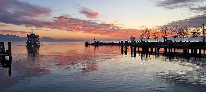 빌라 르 락의 내부에서 바라 본 레만 호수와 알프스의 풍경(위쪽 사진). 창문 높이를 호수 수면 높이에 맞춰 집 안에서 봤을 때 마치 호수 위에 떠 있는 듯한 느낌이 든다. 오른쪽 사진은 노을 질 무렵 레만 호수의 전경. / Patrick Moser/FLC/ADAGP/ProLitteris/2019