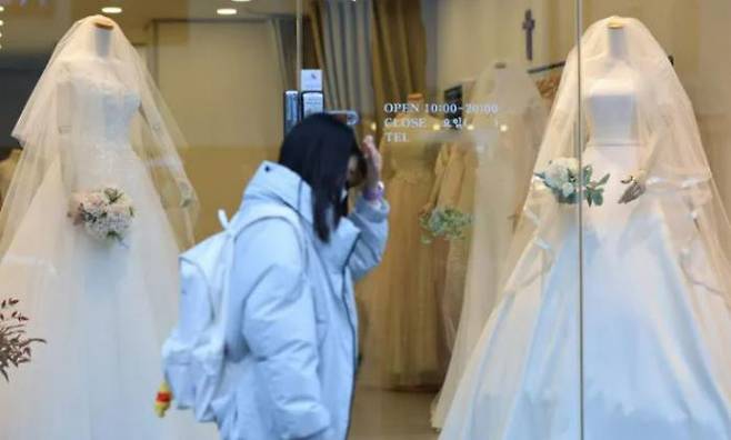 A citizen walks in front of a wedding dress shop in Ahyeon-dong, Mapo-gu, Seoul, on Nov. 11, after statistics showed that the number of newlyweds in their first to fifth year of marriage has fallen to around 1 million couples. Yonhap