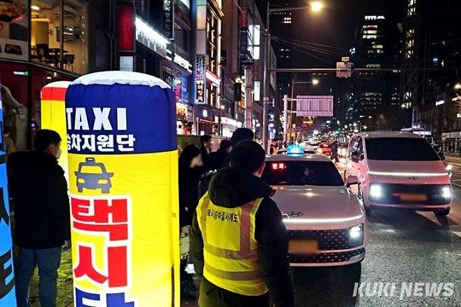 8일 오후 11시30분 서울 관철동 젊음의 거리 입구에 마련된 임시 승차대에서 택시 승차지원단이 택시 탑승 유도를 하고 있다. 사진=임지혜 기자