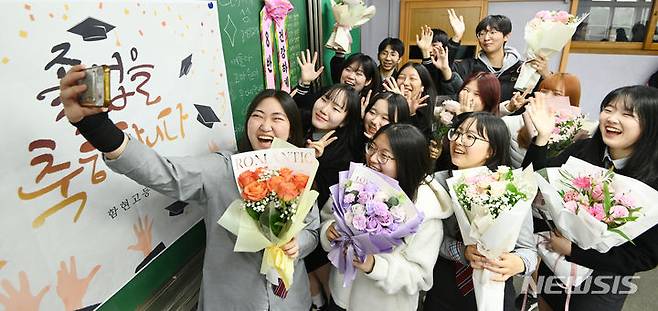 [시흥=뉴시스] 김종택 기자 = 12일 경기도 시흥시 함현고등학교에서 열린 졸업식에서 학생들이 기념촬영 하며 추억을 남기고 있다. 2023.12.12. jtk@newsis.com