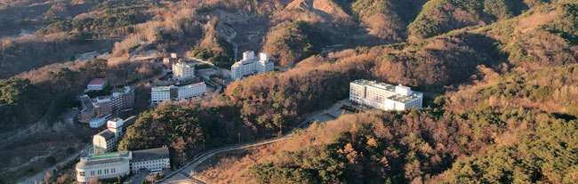 경북 울진의 백암산 아래 백암온천 전경. 숲속에 앉아 있는 오른쪽 흰 건물이 1988년 문을 열었다가 35년 만인 오는 연말에 영업을 중단하는 한화리조트 백암이다. 한화리조트 백암이 문을 닫으면 백암온천에는 온천탕이 딸린 호텔이 딱 4개만 남는다.