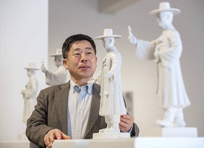 한진섭 조각가가 김대건 신부 성상 제작을 위해 바티칸 교황청에 제출했던 네 가지 모형이 서울 평창동 가나아트센터에 전시됐다. 작가가 이 중에서 최종 채택된 ‘두 팔을 벌리고 모든 것을 포용하고 있는’ 모형을 바라보고 있다. /박상훈 기자