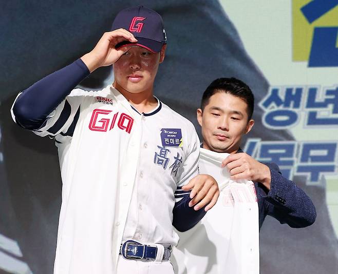 14일 오후 서울 중구 웨스틴조선호텔 그랜드볼룸에서 열린 ‘2024 KBO 신인 드래프트’에서 성민규 롯데 자이언츠 단장이 전체 3순위로 전미르(경북고)를 지명한 뒤 유니폼을 입혀주고 있다. 2023.9.14/뉴스1 ⓒ News1 김진환 기자 /사진=뉴스1