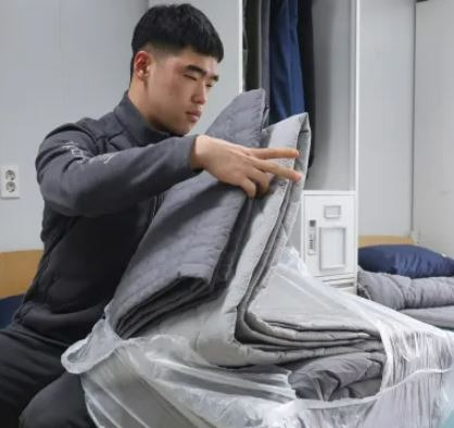 The Defense Department said Sunday that Army and Marine Corps soldiers have completely replaced the fur blankets they used as bedding in their living quarters with commercial comforters this year. A service member checks a commercially laundered comforter. Courtesy of the Department of Defense