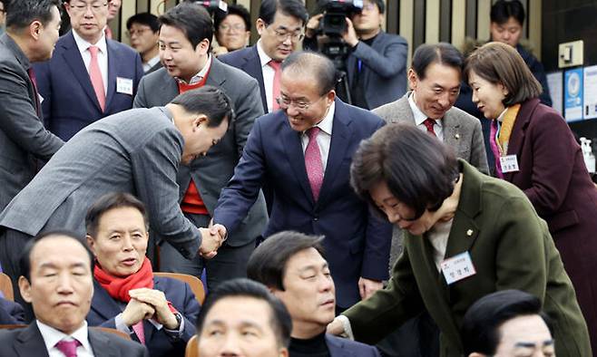 국민의힘 윤재옥 당대표 권한대행(가운데)이 18일 국회에서 열린 국민의힘 국회의원·당협위원장 연석회의에 입장하면서 참석자들과 인사하고 있다. 서상배 선임기자