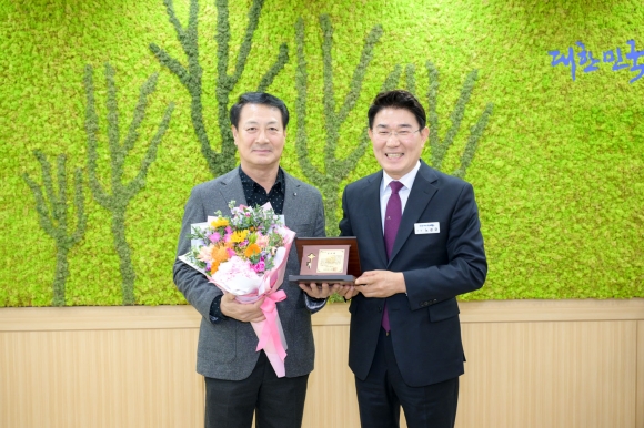 김태성 순천시청 직장운동경기부 총감독이 공로패를 받은 후 노관규 시장과 기념사진을 찍고 있다.