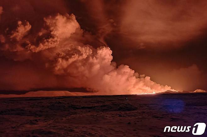 18일(현지시간) 아이슬란드 남서부 레이캬비크 반도의 그린다비크 지역에서 화산이 폭발해 하늘이 빨갛게 보이는 가운데 화산재가 뿜어져 나오고 있다. 2023.12.18 ⓒ AFP=뉴스1 ⓒ News1 정지윤 기자