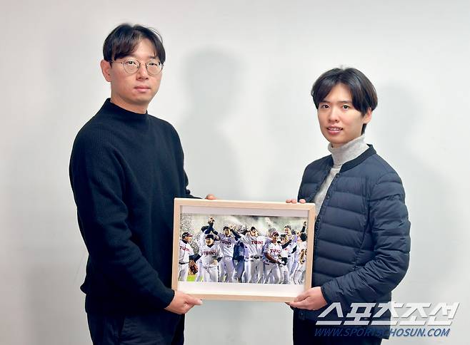 한국스포츠사진기자회 지형준 회장(왼쪽)과 '올해의 야구 보도사진상'을 촬영한 OSEN 조은정 기자가 수상작과 함께 기념 포즈를 취하고 있다. <사진제공=스포츠사진기자회>