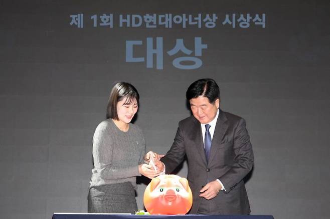 19일 HD현대 글로벌R&D센터에서 열린 제1회 HD현대아너상 시상식에서 ‘얼굴 없는 천사’가 대상을 수상했다. HD현대1%나눔재단 권오갑 이사장(오른쪽)이 '얼굴 없는 천사'를 대신해 전주시 노송동 주민센터 김민아 주무관(왼쪽)에게 대상 상금을 전달하고 있다. 사진제공=HD현대