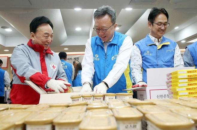 19일 서울 중구 대한적십자사 서울사무소에서 진행된 긴급비상식량세트 제작 봉사활동에서 신한은행 정상혁 은행장(오른쪽)이 식량세트를 제작하고 있다. 신한은행 제공