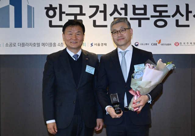 19일 서울 중구 더 플라자 호텔에서 열린 제1회 2023 한국건설부동산산업대상에서 베스트 부동산금융상품 부문을 수상한 코람코라이프인프라리츠의 윤장호(오른쪽) 부사장이 정병윤 한국리츠협회장과 기념촬영을 하고 있다. 성형주 기자