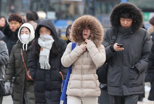 서울 아침 최저기온이 영하 7도까지 떨어진 20일 오전 서울 광화문네거리에서  시민들이 두꺼운 옷을 입은 채 출근하고 있다. 기상청은 이날 낮부터 더 강한 한기가 내려오면서 내일 서울 아침 기온 영하 15도, 체감온도는 영하 21도까지 떨어질 것으로 예보했다./뉴스1