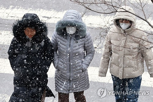 광주와 전남 일부 지역에 대설주의보와 한파주의보가 내려진 20일 오후 광주 서구 치평동에서 시민들이 내리는 눈을 맞으며 도로를 걷고 있다. [광주=연합뉴스]