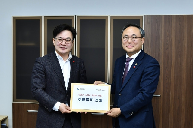 김병수 김포시장이 20일 고기동 행정안전부 차관을 만나 김포시-서울시 통합을 위한 주민투표 건의문을 전달하고 있다. 김포시 제공