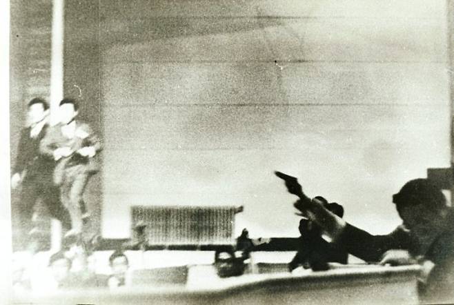 1974년 8월15일 오전 10시23분쯤 광복절 기념식이 열린 서울 장충동 국립극장에서 문세광이 박정희 대통령과 부인 육영수씨를 향해 총을 쏜 뒤 객석에서 내민 발에 걸려 넘어지기 직전 오케스트라석 분리대를 짚고 단상으로 권총을 겨냥하고 있다. /사진=서울기록원