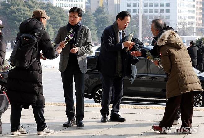 [서울=뉴시스] 조성봉 기자 = 20일 오후 서울 여의도 국회 본청 입구에서 이태원참사 유가족들이 '이태원참사 특별법 국회 본회의 통과'를 촉구하며 더불어민주당 고용진, 김두관 의원에게 보라색 꽃다발을 나눠주고 있다. 2023.12.20. suncho21@newsis.com