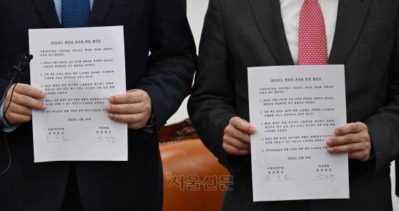 윤재옥(오른쪽) 국민의힘 원내대표와 홍익표 더불어민주당 원내대표가 20일 국회에서 2024년도 예산안 처리를 위한 합의를 마친 뒤  합의문을 들어 보이고 있다. 2023.12.20 홍윤기 기자