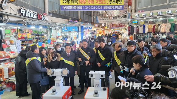 문헌일 서울시 구로구청장(왼쪽에서 다섯번째), 오세훈 서울시장 등이 남구로시장에서 화재순찰로봇 시연에서 설명을 듣고 있다. [사진=정종오 기자]