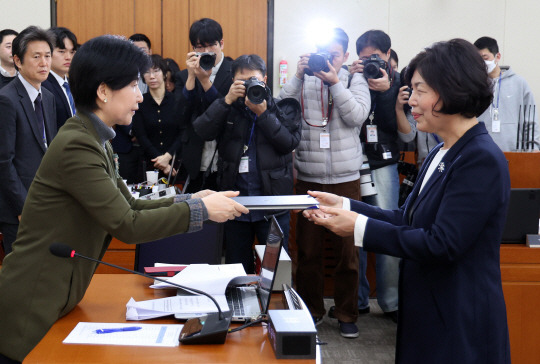 강정애(오른쪽)  국가보훈부 장관 후보자가 21일 오전 서울 여의도 국회에서 열린 인사청문회에서 백혜련(왼쪽) 정무위원장에게 선서문을 전달하고 있다. 뉴시스