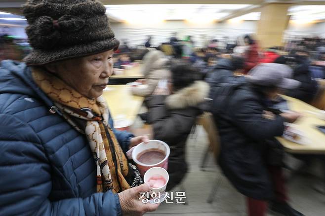 밤이 가장 길고 낮이 가장 짧아진다는 절기상 동지인 22일 서울 종로구 조계사에서 열린 팥죽 공양 행사에서 시민들이 팥죽을 받은 뒤 이동하고 있다. 성동훈 기자