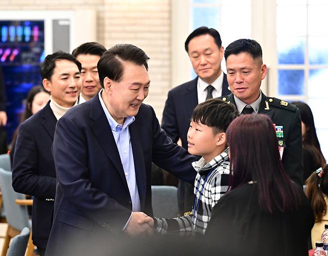 윤석열 대통령이 22일 서울 용산 대통령실 파인그라스에서 열린 ‘히어로즈 패밀리와 함께하는 꿈과 희망의 크리스마스’ 행사에서 참석한 아이들과 인사를 하고 있다.
 히어로즈 패밀리는 전몰·순직한 군인·경찰·소방관 등의 미성년 자녀와 배우자를 말하는 것으로 이번 행사에는 제복 영웅의 초등학생 이하 자녀 14명과 배우자 등 30여 명이 참석했다. 이승환기자