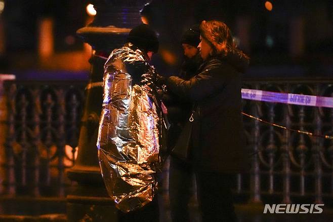 [프라하=AP/뉴시스] 21일(현지시간) 체코 프라하 카렐대학교 철학과 건물 인근에서 시민들이 온열 담요를 두른 채 대화하고 있다. 체코 경찰에 따르면 이 학교에서 대규모 총격이 발생해 15명이 숨지고 24명이 다쳤다. 2023.12.22.