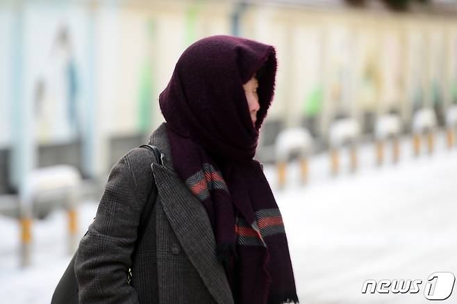 한파와 함께 폭설이 내린 21일 오전 광주 동구 대의동에서 한 시민이 목도리를 얼굴에 두르고 발걸음을 옮기고 있다.2023.12.21/뉴스1 ⓒ News1 이승현 기자