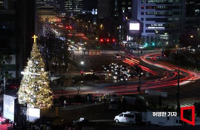 서울시청 앞 서울광장에서 20일 저녁 크리스마스 트리 점등식이 열렸다. 불 밝힌 트리 옆으로 시민들과 차들이 지나가고 있다. 사진= 허영한 기자 younghan@